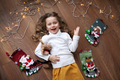 Happy Child girl lying on floor at Christmas and looking at camera. Xmas decor, garland lights bulb - PhotoDune Item for Sale