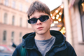 Stylish handsome teen guy wear sunglasses outdoor over city lights - PhotoDune Item for Sale