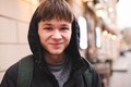 Smiling handsome funny teen guy wear hood outdoor over city lights - PhotoDune Item for Sale