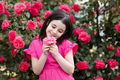 Cute laughing kid girl with rose flowers in park outdoor - PhotoDune Item for Sale