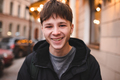 Smiling handsome funny teen guy wear hoody outdoor over city lights  - PhotoDune Item for Sale