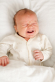 Sick baby crying with colic pain in bed - PhotoDune Item for Sale