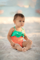 Little toddler girl in swimsuit sitting on sandy beach at summer vacation - PhotoDune Item for Sale