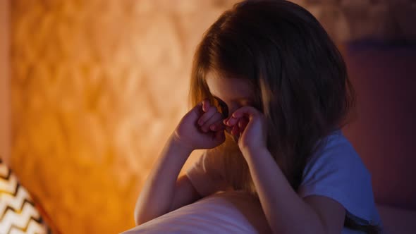 Offended Little Girl Rubs Eyes on Bed Near Decorative Tent