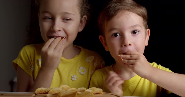 Cute Little Funny Kids Boy and Girl Eat Potato Chips Kids Take Chips and Have Fun Kids Eat at the