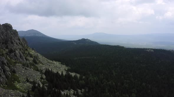 Drone Moving Forward Near Rocky Cliff