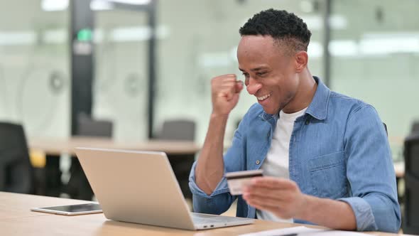 Successful Casual African Man Making Online Payment on Laptop