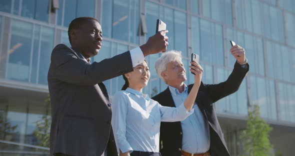 Medium Shot of Diverse Business People Outside Taking Selfie on Smartphone