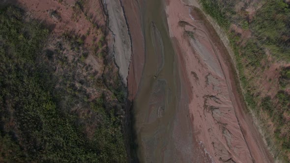 Aerial view looking down at river flowing through the desert