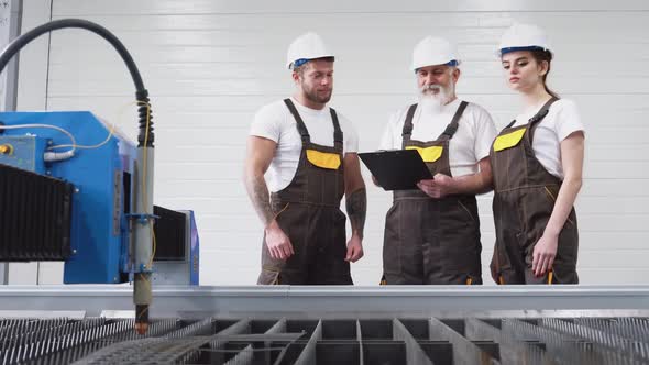 Three Engineers Inspecting Plasma Cutter