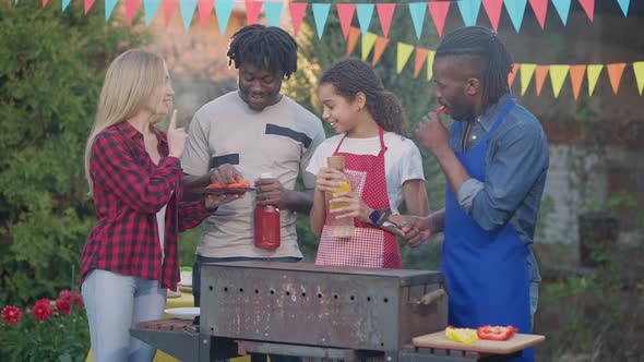 Middle Shot of Cheerful Laughing Group of Multinational Young People Chatting on Picnic Outdoors