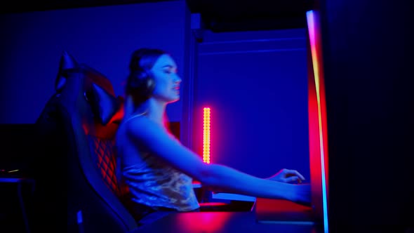 Tattooed Young Woman Sitting in Neon Gaming Club - Playing Game and Gets Dissapointed