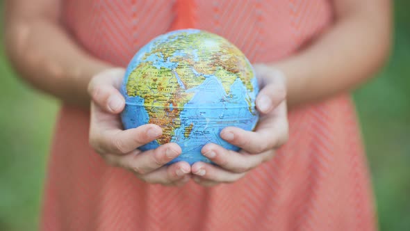 The Little One is Holding a Geographic Globe