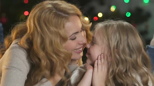 Cheerful Mother and Daughter Having Fun, Nuzzling Near Christmas Tree, Holidays