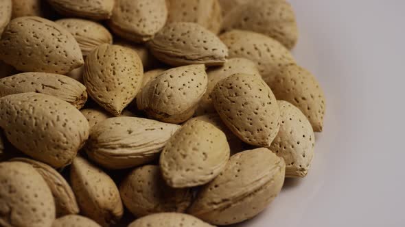 Cinematic, rotating shot of almonds on a white surface - ALMONDS