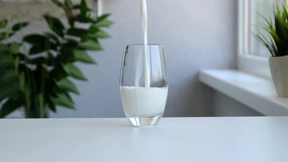 Milk Poured Into Transparent Glass Closeup