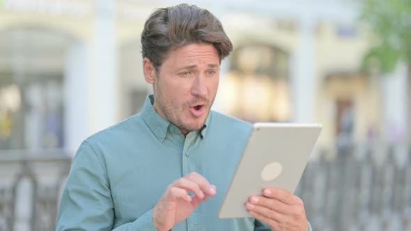Man having Loss on Tablet Outdoor