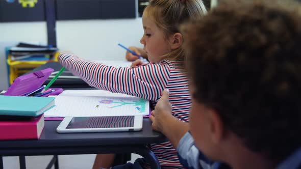 Schoolboy borrowing color pencil from his classmate