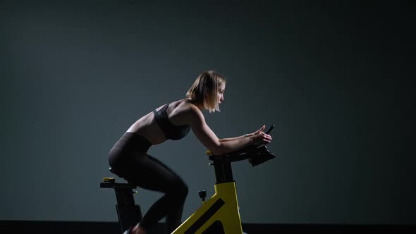 Cycle Training Young Woman is Engaged in Fitness on a Spin Bike Performs Aerobic Endurance Training