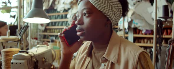 African American Woman Talking on Phone in Workshop
