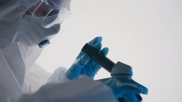 Virologist or Scientist is Looking Into Microscope alt