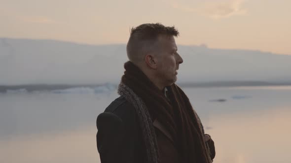 Man Looking Around In Cold Sunset Landscape