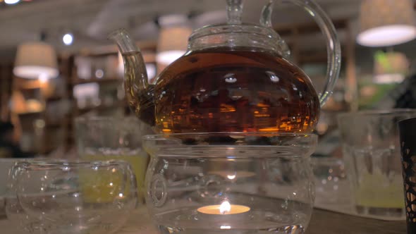 Glass teapot being heated with candle