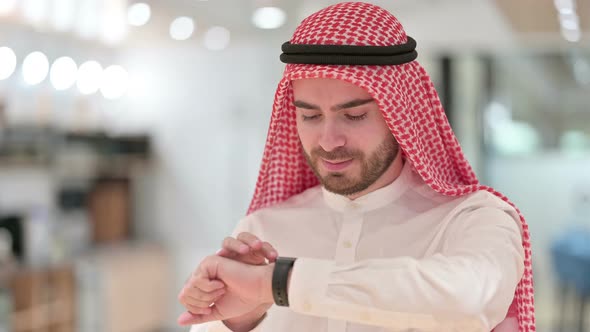 Portrait of Serious Arab Businessman Using Smartwatch