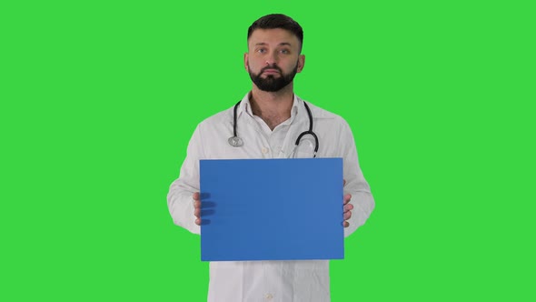 Arab Doctor Standing Showing Placard and Telling Something on a Green Screen, Chroma Key.