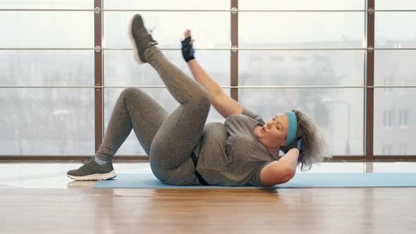 Fat Woman Doing Crunches in the Gym Center