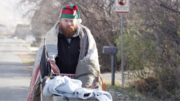 Homeless man pushing cart down neighborhood street