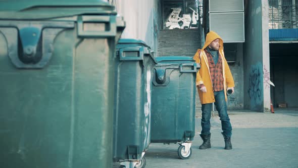 A Homeless Man is Rummaging in the Waste Bins