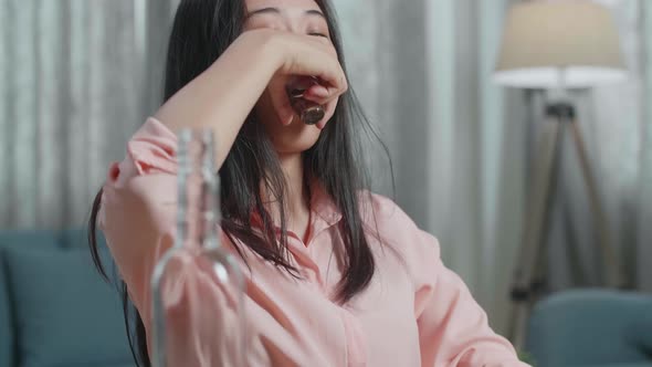 Close Up Of Asian Woman Drinking Vodka While Typing On A Laptop At Home