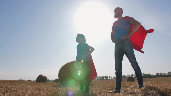 Playful Dad and Son Dressed As Supermen Outdoor