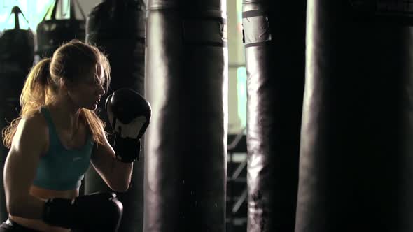 Woman does Muay Thai kickboxing training at the gym.