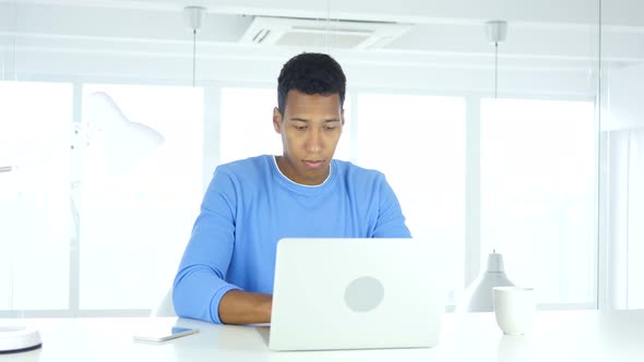 Afro-American Man Working On Laptop in Office