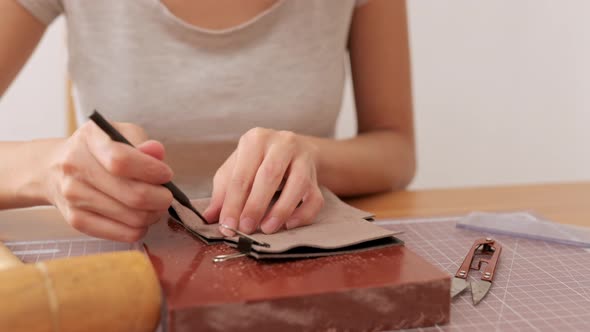 Woman making leather craft at home