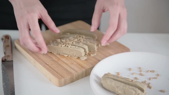 Lady serves brown halva slices