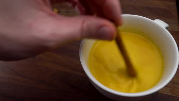 Man Stirs Golden Milk Turmeric Health Drink Cinnamon Stick