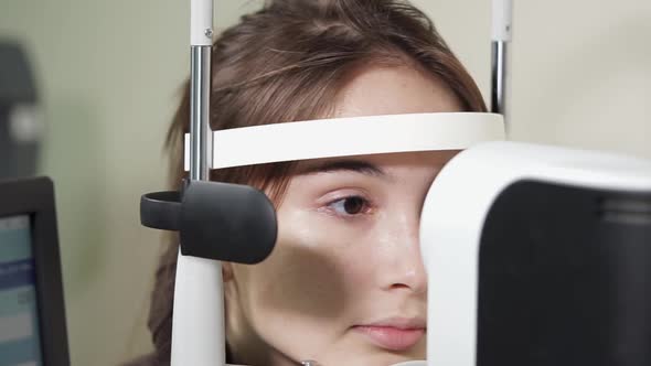 Portrait of Teenager Who Undergoes the Procedure of an Ophthalmoscopy in Clinic