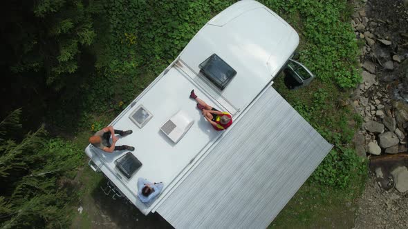 Family on Their Camper Van Motorhome Roof Enjoying the Sun