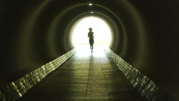 Shot of Woman Jogger Running Through the Illuminated Tunnel