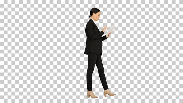 Businesswoman using a tablet pad while walking, Alpha Channel