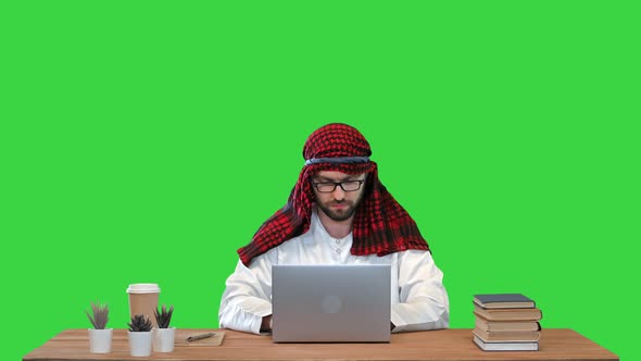 Arabian Businessman Using Laptop at the Table on a Green Screen Chroma Key