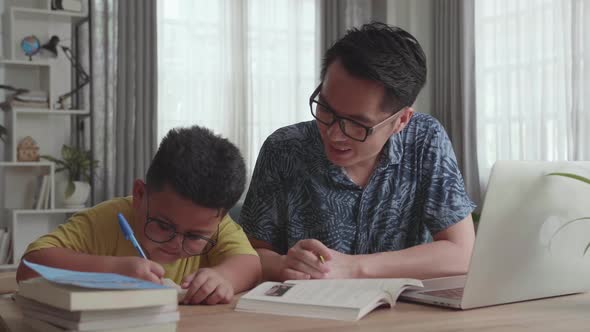 Caring Father Help Son With School Subject. Little Boy Use Laptop Makes Notes