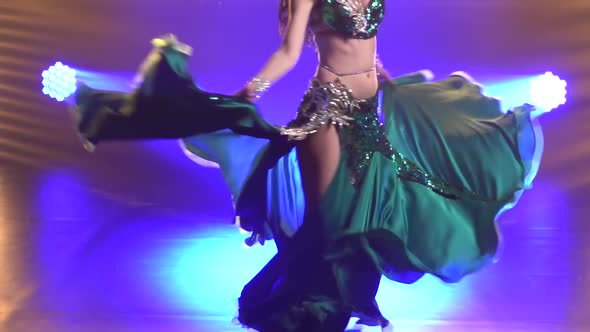 Graceful Torso of a Young Female Belly Dancer in a Shiny Oriental Costume. Girl Whirls in a Dance
