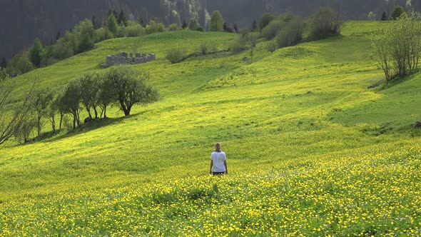 Blond Haired Alone Woman is Watching View in Yellow Flowery Meadow