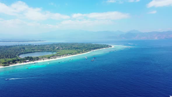 Peaceful sea scenery of blue azure lagoon around shore of tropical island with boats anchored near w