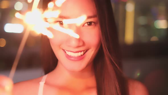 Young asian woman with sparklers is dancing and celebrating a new year. Fireworks,