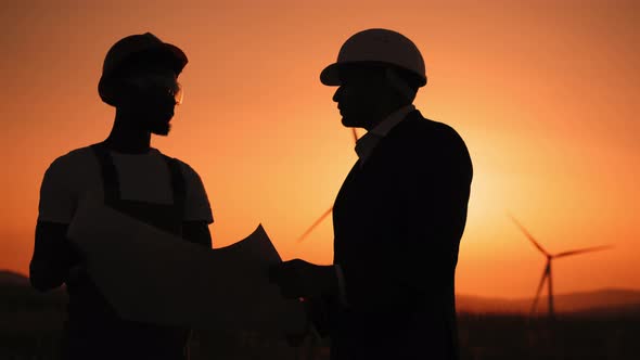 Silhouette Close Up Face Two Professionals Technicians in Hard Hat Using a Large